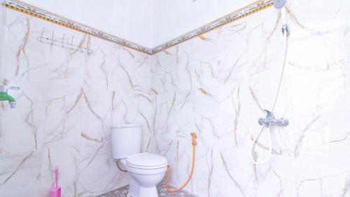 a bathroom with a white toilet and a shower at Villa Panderman Asri with Private Pool and Rooftop in Tlekung