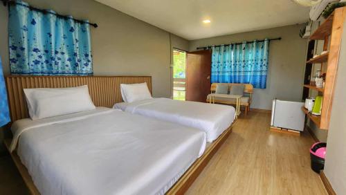 a bedroom with two beds and a table and a chair at ID Garden Home in Ban Cham Kha