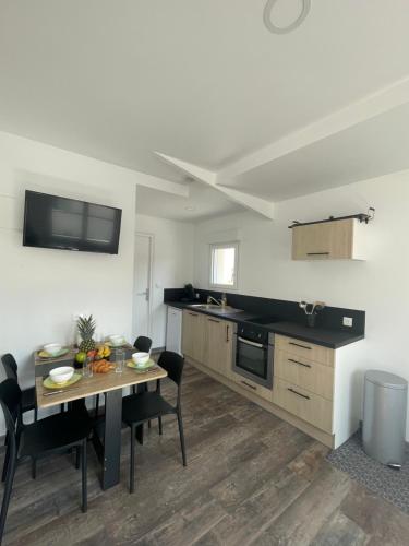 une cuisine et une salle à manger avec une table et des chaises dans l'établissement Maison Cozy à Saint-Brevin à Deux Pas de la Mer, à Saint-Brévin-les-Pins