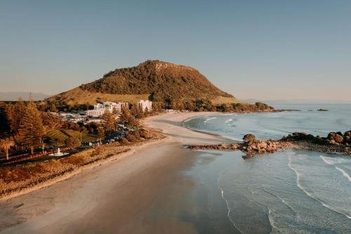 an aerial view of a beach with a mountain at Mount Maunganui Gem Long Stay Ready Steps to It All in Mount Maunganui