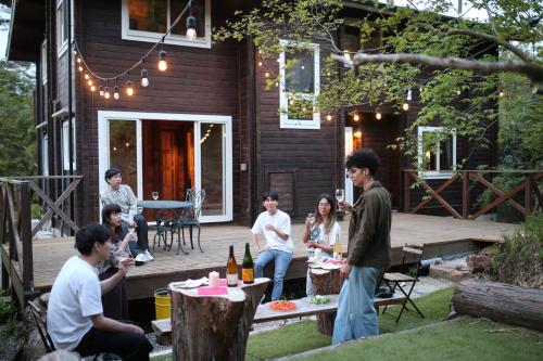 a group of people sitting on the deck of a house at RENEST in Kobe