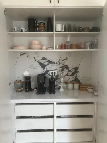 a kitchen with white shelving with appliances in it at Villa Sienna in Ruđinci
