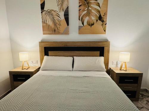 a bedroom with a large bed with two lamps on tables at Aladín House Vinaròs playa in Vinaròs