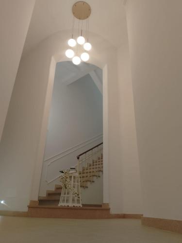 a hallway with a staircase with a chandelier at Palazzo Annarita in Brindisi