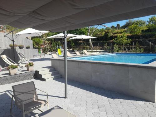 una piscina con una silla y una sombrilla en Sikelia Etna House, en Zafferana Etnea