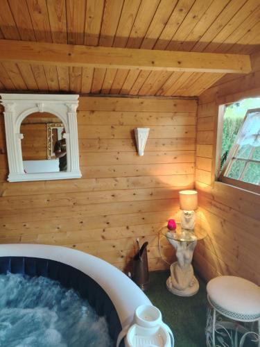 une baignoire dans le coin d'une maison en bois dans l'établissement Chez Fabiola et Alain, à Signy-le-Petit