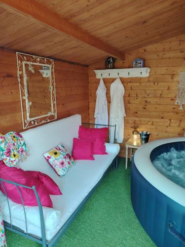 - un salon avec un canapé blanc et une baignoire dans l'établissement Chez Fabiola et Alain, à Signy-le-Petit