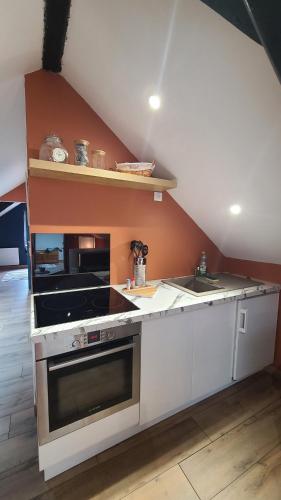une cuisine avec une cuisinière et un évier dans l'établissement Appartement de 50m cosy et bien aménagé, à Maîche