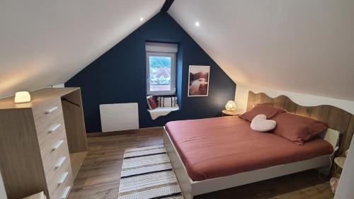 une chambre avec un lit et un mur bleu dans l'établissement Appartement de 50m cosy et bien aménagé, à Maîche