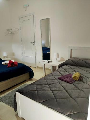 a bedroom with two beds and a mirror at Bed and fly Aeroporto Catania in Catania