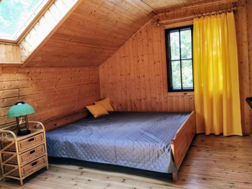 a bedroom with a bed in a wooden house at Dom Pilchy nad jeziorem Roś in Pilchy