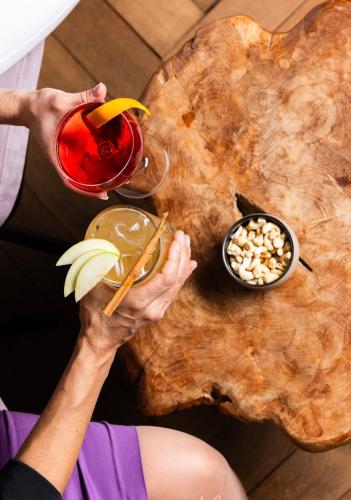 a person holding a drink on top of a wooden table at Rössli Hurden in Hurden