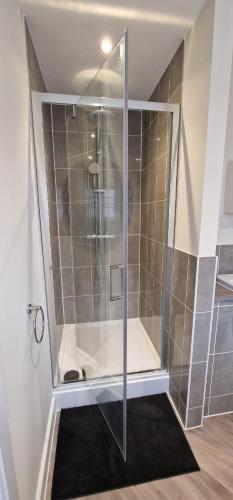 a shower with a glass door in a bathroom at Spacious Colchester Home with Off-Street Parking for 4 cars in Colchester