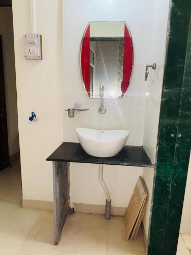 a bathroom with a sink and a mirror at Samartha Krupa Homestay in Wai
