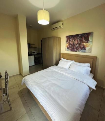 a bedroom with a large bed with white sheets and pillows at Le31residence in Zouk Mikael