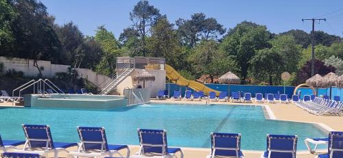 une grande piscine avec des chaises et un toboggan dans l'établissement Evasion au bord de l'océan, à Capbreton