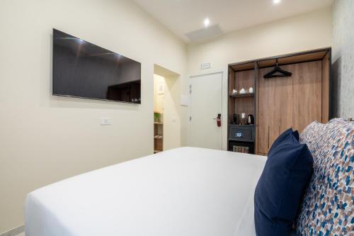 a bedroom with a bed and a flat screen tv at 69 Suite Boutique in Rome