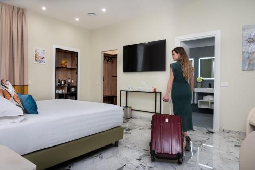 a woman standing in a hotel room with a suitcase at 69 Suite Boutique in Rome