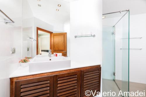 a bathroom with a sink and a glass shower at KB Apartments Karon Beach by PHR in Karon Beach