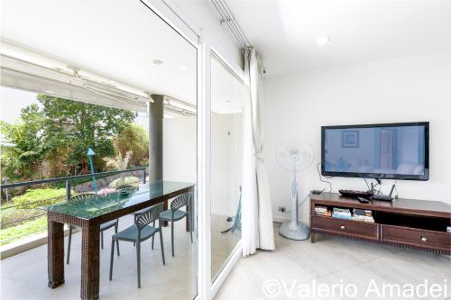 a dining room with a table and a tv at KB Apartments Karon Beach by PHR in Karon Beach