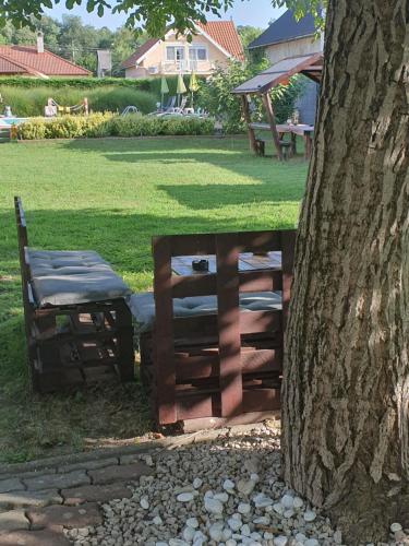 a bench next to a tree next to a tree at Főnix Üdülőház Zamárdi in Zamárdi