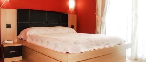 a bedroom with a large bed with a black headboard at Hotel Vivas in Durrës