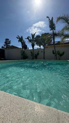 a swimming pool with turquoise water and palm trees at Morgana Sea in Catania
