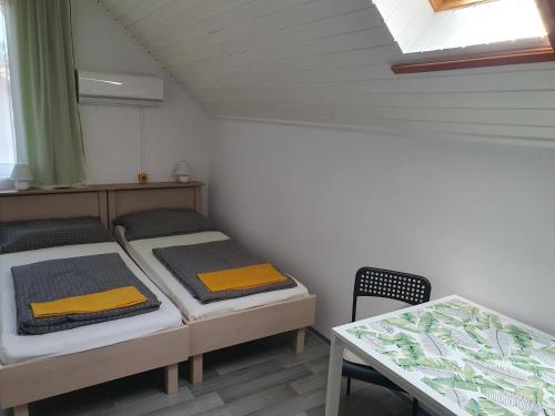 a small room with two beds and a table at Főnix Üdülőház Zamárdi in Zamárdi