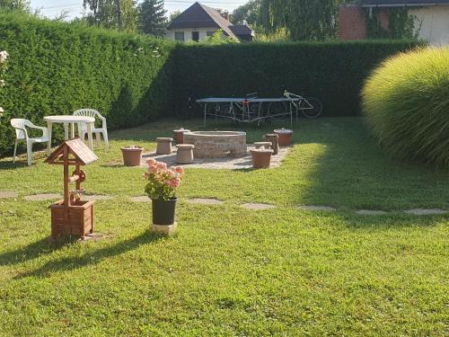 a garden with a picnic table and flowers in the grass at Főnix Üdülőház Zamárdi in Zamárdi