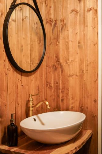 a bathroom with a white sink and a mirror at Heimbrygga Restaurant & Accommodation in Skrova