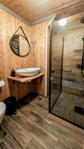 a bathroom with a sink and a glass shower at Heimbrygga Restaurant & Accommodation in Skrova