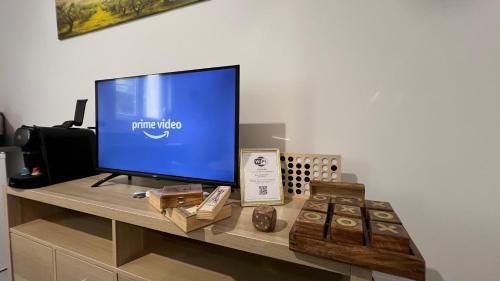 a television sitting on a desk with a table with cupcakes at Fenix Appartement T2 40 M2 cosy RDC plein centre ville in Pierrelatte