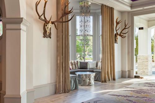 a living room with a couch and a chandelier at Castle Hotel, Autograph Collection in Orlando
