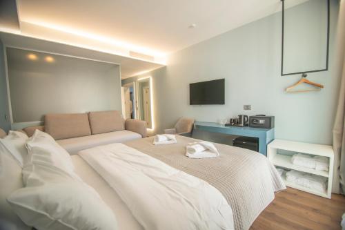 a bedroom with a large bed and a couch at Hotel Porta Ksamil in Ksamil