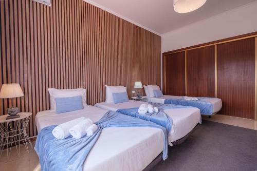 a hotel room with two beds with towels on them at Areal de Santa Bárbara Guest House in Ribeira Grande