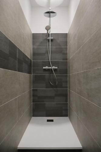 une salle de bain avec douche aux carreaux gris dans l'établissement Duo de maisons 2 min de la plage, à Saint-Brévin-les-Pins