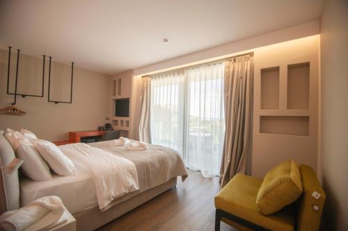 a bedroom with a bed and a large window at Hotel Porta Ksamil in Ksamil