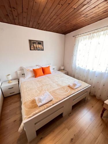 a bedroom with a large bed with orange pillows at Lavanda Apartment in Stari Grad