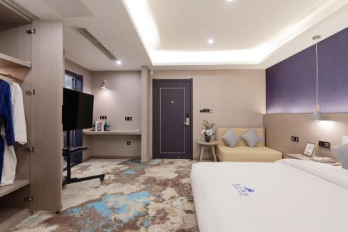 a hotel room with a bed and a tv at Cavalier Hotel Chongqing in Chongqing