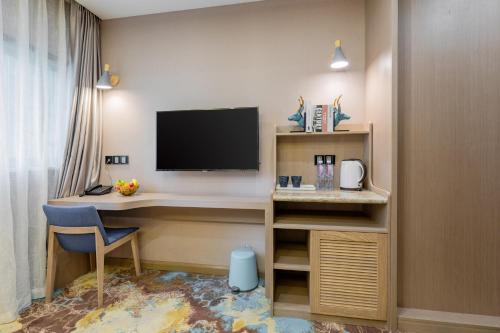 a room with a desk with a tv and a computer at Cavalier Hotel Chongqing in Chongqing