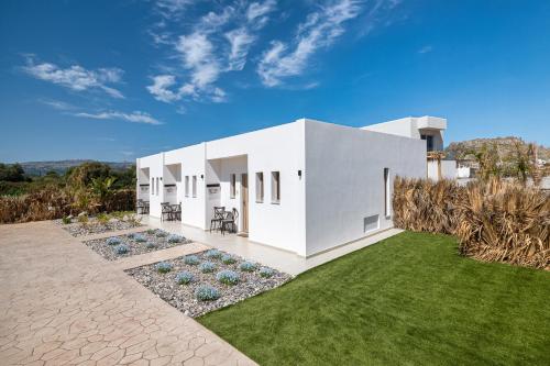 a white house with a green lawn at The Azure Suites in Haraki