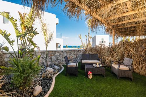 a patio with chairs and a table and aiki at The Azure Suites in Haraki