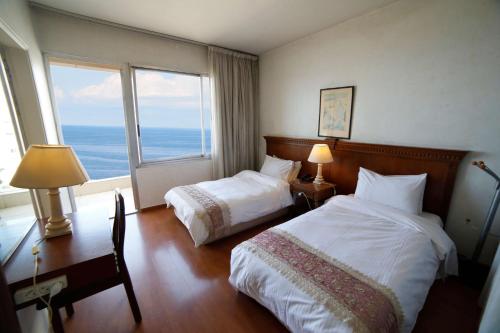 a hotel room with two beds and a large window at Holiday Home Suites in Beirut