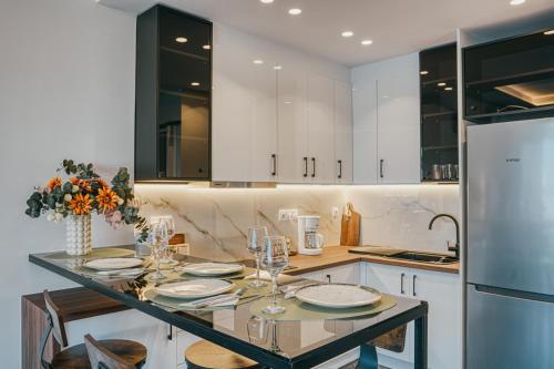 a kitchen with a table with plates and wine glasses at NOA-Luxury Stay with a view in Chios