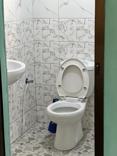 a bathroom with a toilet and a sink at Karibu Eco-Hostel Arusha in Arusha