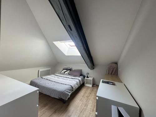 - une petite chambre avec un lit et une lucarne dans l'établissement Charmant duplex cosy au centre ville, à Périgueux