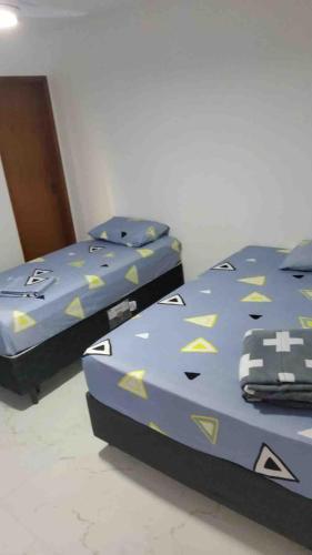 two beds sitting next to each other in a bedroom at Luxo com Spa exclusivo no paraíso do Peró! in Cabo Frio