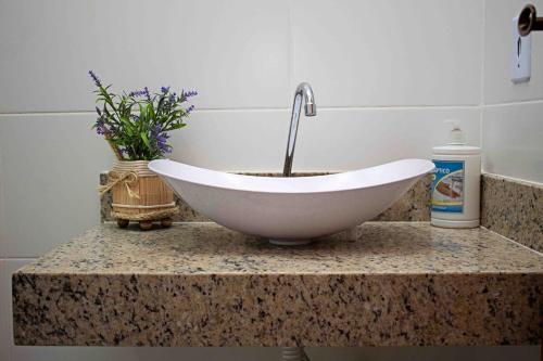 a white sink sitting on a counter in a bathroom at Luxo com Spa exclusivo no paraíso do Peró! in Cabo Frio
