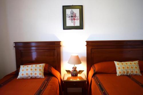 dos camas sentadas una al lado de la otra en un dormitorio en Matalbatz Hotel, en Cobán