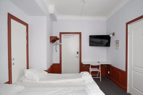a hotel room with two beds and a desk at Hotell Skeppsbron in Stockholm